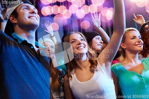 Image of smiling friends at concert in club