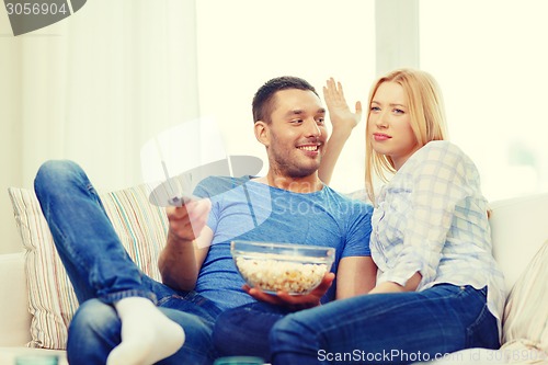 Image of smiling couple with popcorn choosing what to watch