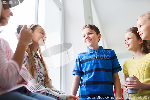 Image of group of school kids with soda cans in corridor