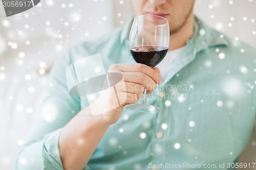 Image of close up of man drinking red wine at home