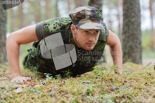 Image of young soldier or ranger doing push-ups in forest