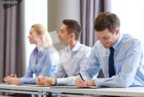 Image of group of smiling businesspeople meeting in office