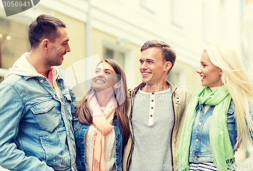 Image of group of smiling friends walking in the city