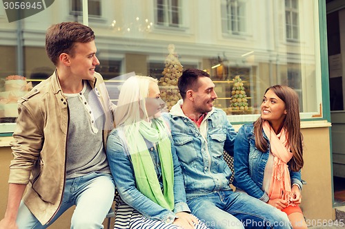 Image of group of smiling friends walking in the city