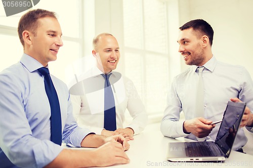 Image of smiling businessmen having discussion in office