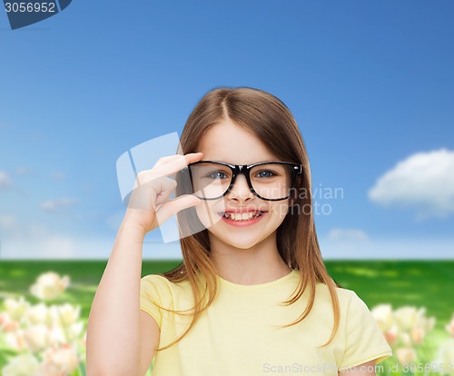 Image of smiling cute little girl in black eyeglasses