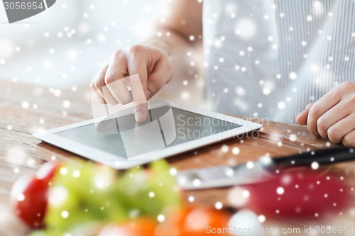 Image of close up of man reading recipe from tablet pc