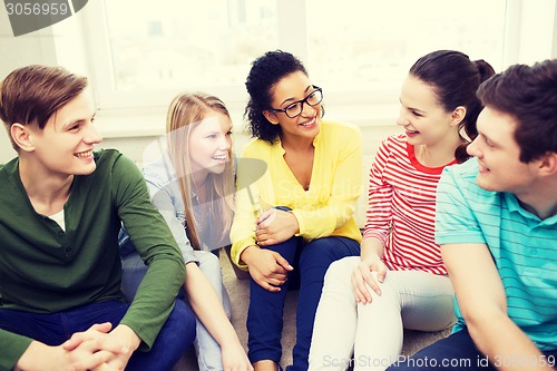 Image of five smiling teenagers having fun at home