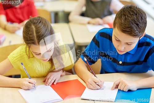 Image of group of school kids writing test in classroom