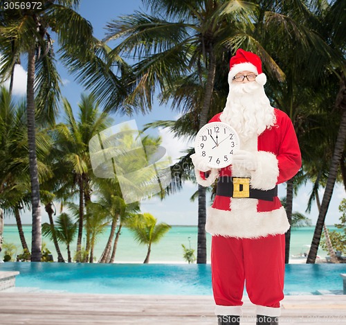 Image of man in costume of santa claus with clock