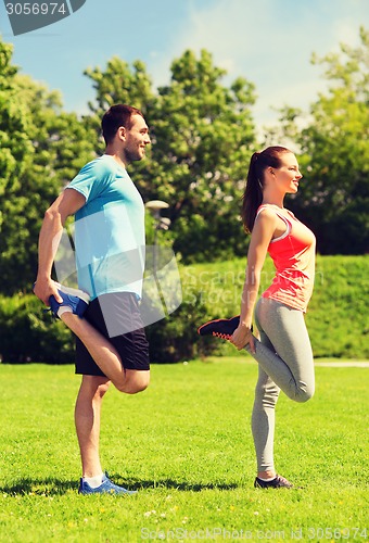 Image of smiling couple stretching outdoors