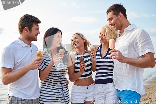 Image of friends eating ice cream and talking on beach