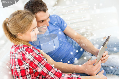 Image of smiling couple with tablet pc computer at home