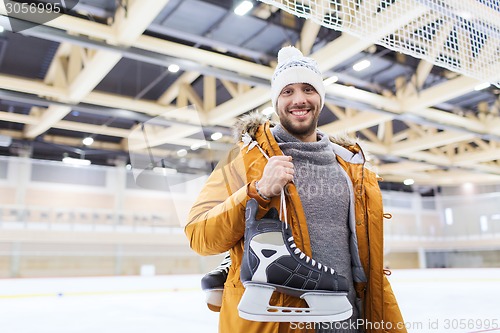 Image of happy young man with ice-skates on skating rink