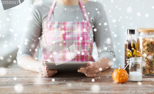 Image of close up of woman reading recipe from tablet pc