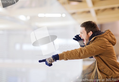 Image of young man supporting hockey game on skating rink