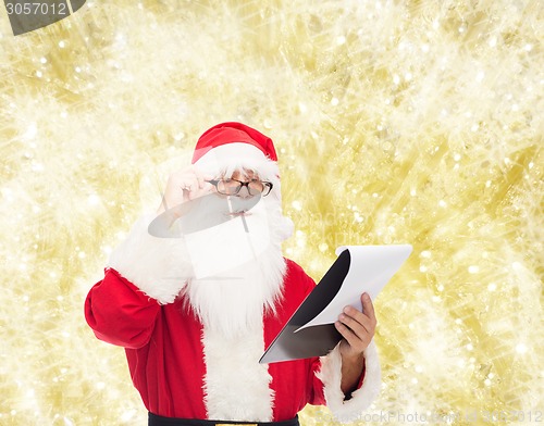 Image of man in costume of santa claus with notepad