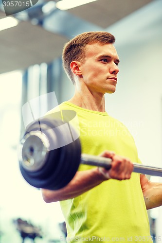 Image of man doing exercise with barbell in gym