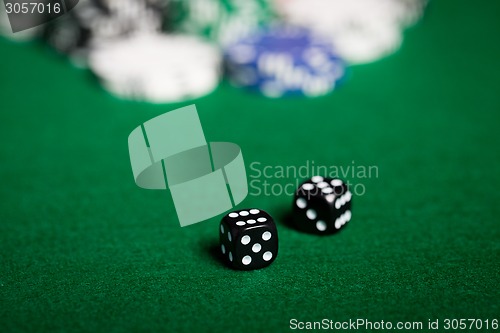 Image of close up of black dices on green casino table