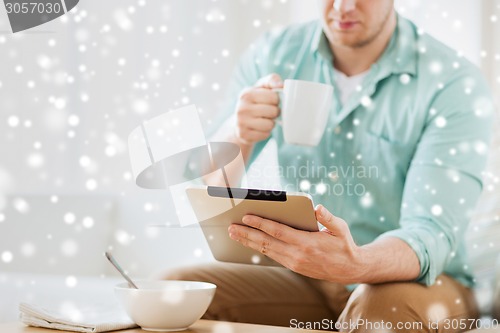 Image of close up of man with tablet pc having breakfast