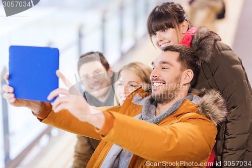Image of happy friends with tablet pc on skating rink