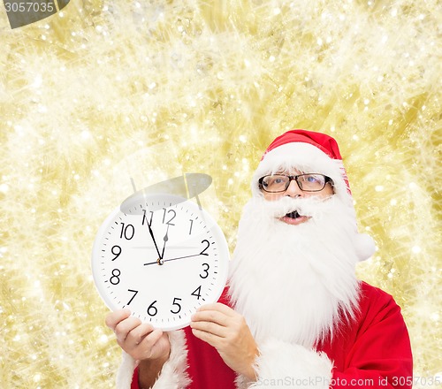 Image of man in costume of santa claus with clock