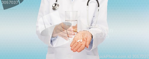 Image of close up of doctor offering pills and water