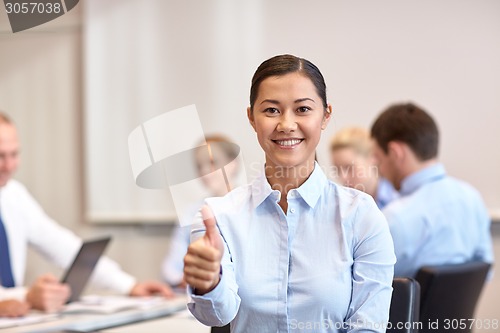 Image of group of smiling businesspeople meeting in office