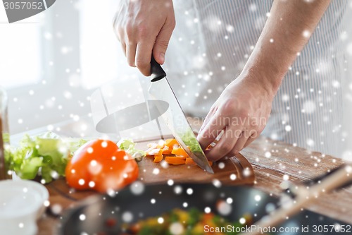 Image of close up of man cutting vegetables with knife