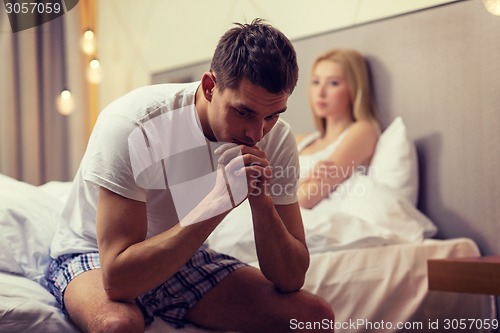 Image of man sitting on the bed with woman on the back