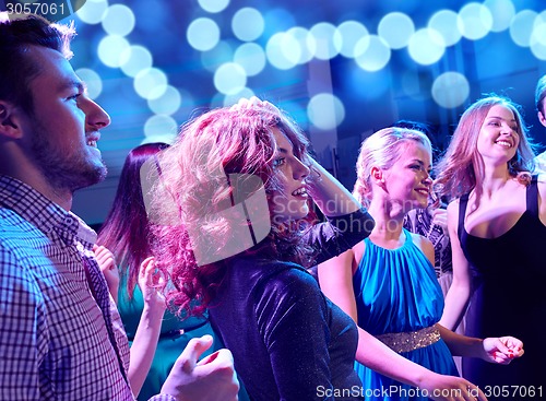 Image of smiling friends dancing in club