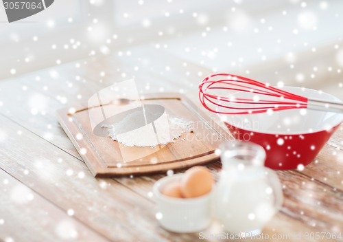 Image of close up of milk jug, eggs, whisk and flour