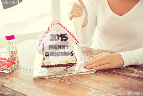 Image of close up of woman making gingerbread houses