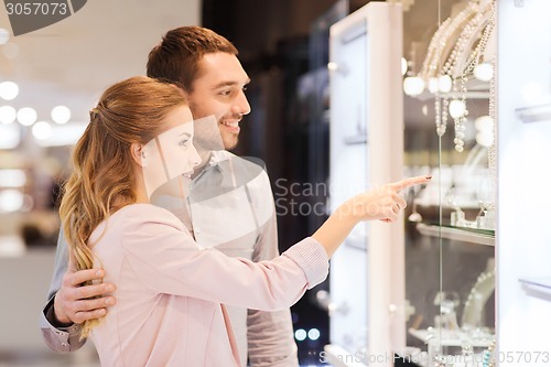 Image of couple looking to shopping window at jewelry store