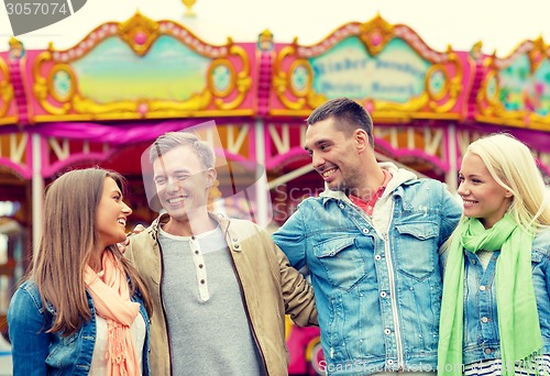 Image of group of smiling friends in amusement park