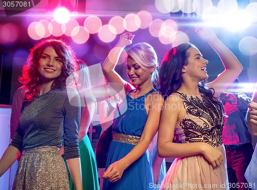 Image of smiling friends dancing in club