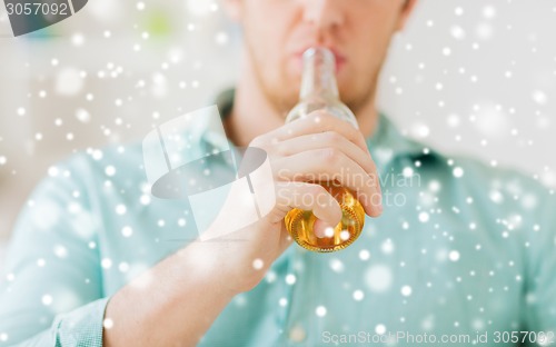 Image of close up of man drinking beer at home