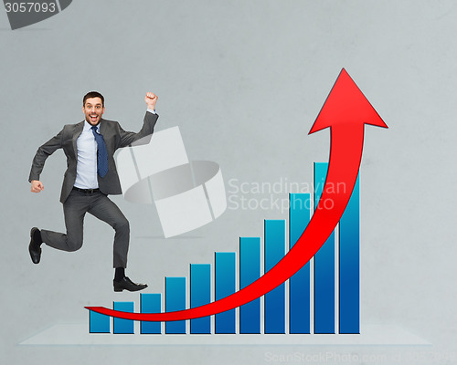 Image of happy businessman jumping over growth chart