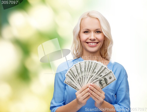 Image of smiling young woman with us dollar money