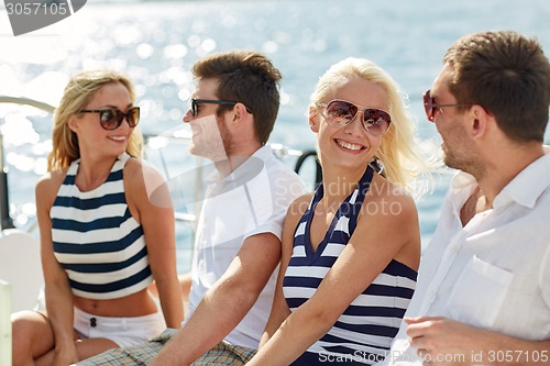 Image of smiling friends sitting on yacht deck