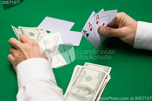 Image of poker player with cards and money at casino