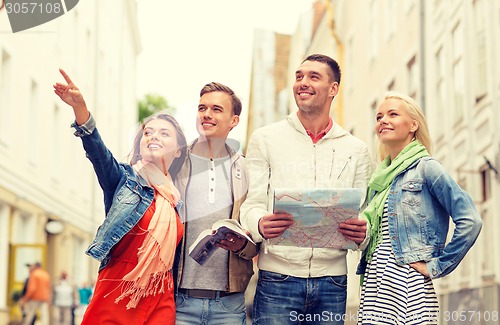 Image of group of smiling friends with city guide and map