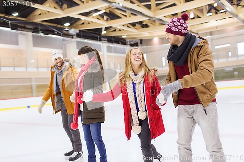 Image of happy friends on skating rink