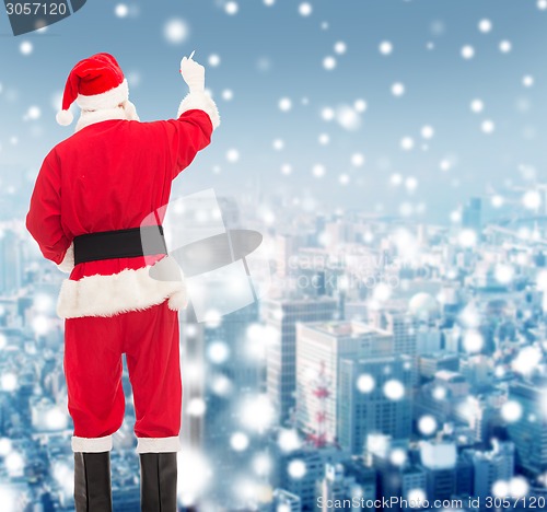 Image of man in costume of santa claus writing something