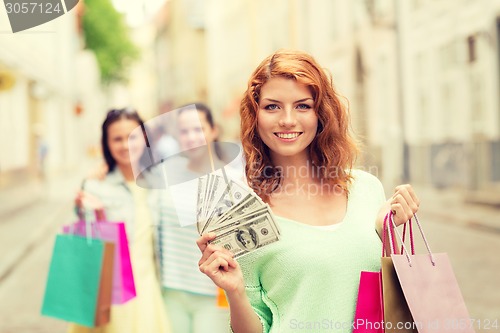 Image of smiling teenage girls with shopping bags on street