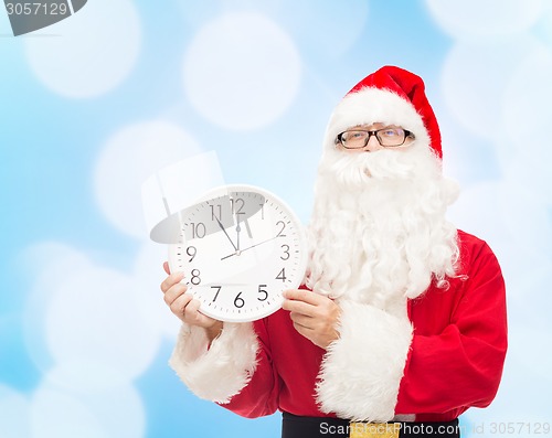 Image of man in costume of santa claus with clock