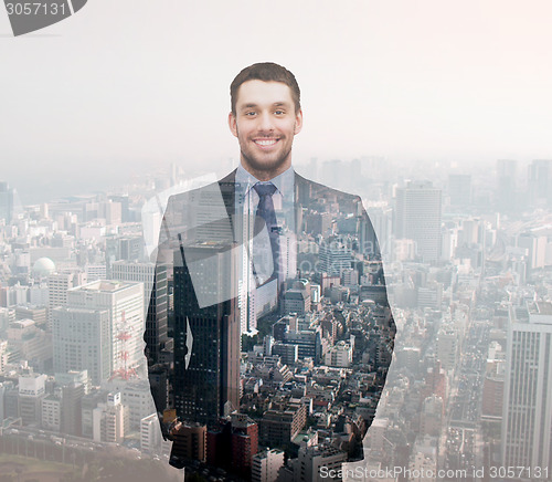 Image of smiling young buisnessman over city background