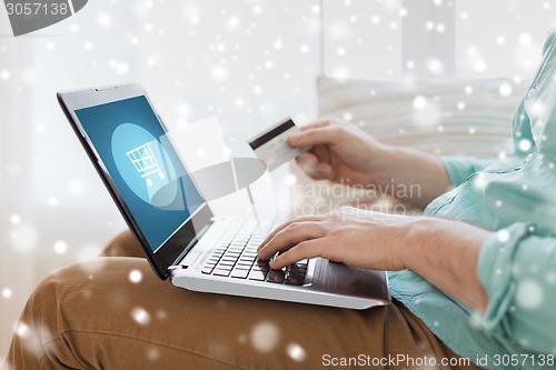 Image of close up of man with laptop and credit card