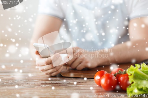 Image of closeup of man reading recipe from smartphone