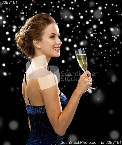 Image of smiling woman holding glass of sparkling wine